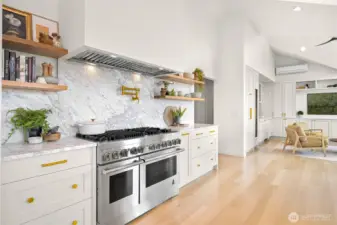 Quartz countertops and a matching quartz backsplash create a sleek, modern aesthetic while offering durability for any culinary adventure. A custom range hood adds both style and function, perfectly complementing the Jenn Air commercial-grade appliances. The thoughtful design continues with a pot filler conveniently positioned above the range, merging practicality with elegance.