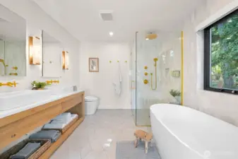 Inside, the spa-like primary bath is designed to pamper, featuring heated tile floors for a touch of everyday indulgence, sleek Kohler faucets, and a sense of calm sophistication.