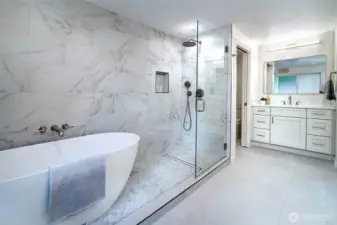 Completely remodeled primary bathroom with beautiful tile work, multiple vanities, soaking tub and shower.