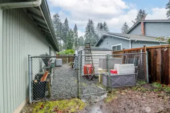 Side yard is fenced and provides additional storage sheds.