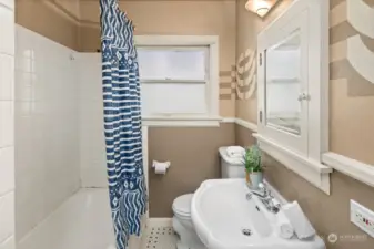 Full bathroom on the main floor with original tile and hand-painted accents.