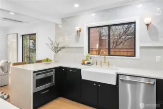 This photo showcases the quartz waterfall island, posh full-height quartz and tile backsplash...