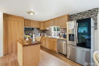 Beautiful remodeled kitchen featuring granite countertops and backsplash, stainless steele appliances, and island!