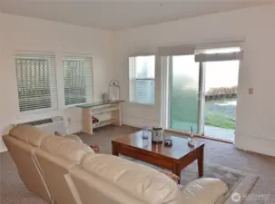 Living Room w/ 2 extra windows because it is a corner unit.  Slider leads out to the back of the building and then to the path to the Beach through the Dunes.