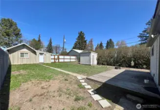 Back yard with deck off 2 bedroom house. Fence separates the yard from the alley.