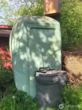Extra large antique port-a-potty. Painted to match stand shed trim.