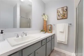 Close up of the Primary bathroom with walk in shower.  Vinyl tile flooring and new hardware on the vanity