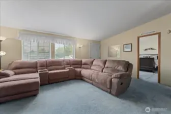 Front door opening into the living room, view of primary bedroom