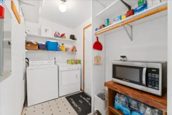 Laundry room arranged with a microwave cutout/alcove and a back-door exit to the yard