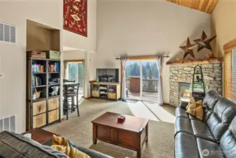 A stone fireplace with a handcrafted log mantle grounds the space in warmth and character.