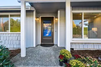 The freshly painted entry door and attractive shake style accent siding offer a warm welcome.  Keep dry or cool under the convenient covered entry porch. The entry screen and storm door with window invites fresh air and light while discouraging insects!