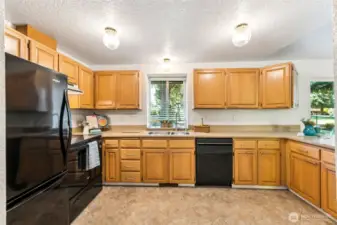 Generous kitchen area with custom pullout hardware and view to the backyard and 18th fairway. Large panty adjacent.