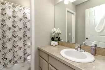 Full bathroom upstairs between extra bedrooms. Pocket door closes off to the tub / shower and commode to the sink and cabinets.