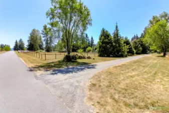 This view is of the driveway from 152nd Ave. E. The first fenced area behind the tree is a sand footed horse arena.