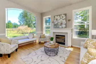 Full view of the formal living room with large picture window, vaulted ceilings and a beautiful view of the horse pastures.