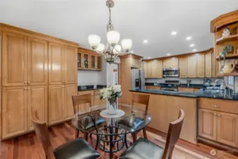 Eat in space near kitchen showcases the extensive pantry cupboard wall, coffee station, and spacious kitchen.