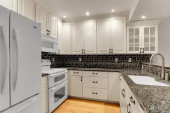 Large kitchen with granite countertops, undermount lighting and lots of cabinet space.