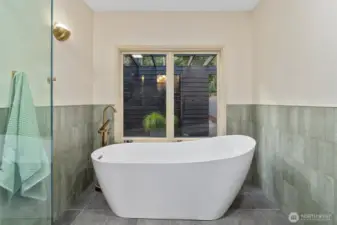 Relax in your master suite with a newly renovated bathroom, featuring a large soaking tub and elegant art deco tiles.