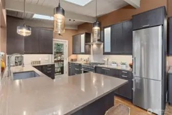 Designer kitchen showcases quartz counters, custom cabinetry & high-end stainless appliances.