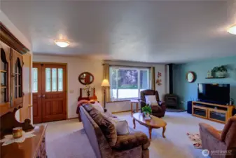 Spacious living room with picture window and propane fireplace.