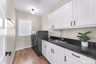 Large Laundry room with utility sink, tons of storage cabinets and washer/dryer stays with home!