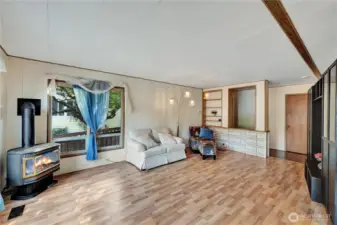 The cheerful living room features beautiful flooring & a free-standing gas stove.