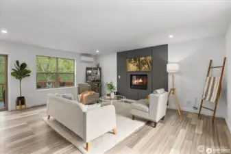 Windows flood the living area with light, showcasing the surrounding trees and forest while providing privacy