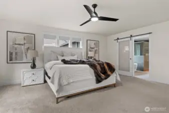 With it's own attached bathroom and trendy sliding barn door, this primary bedroom is designed for luxury.