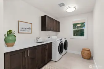Desirable laundry room with sink and cabinetry storage makes this chore a bit easier!