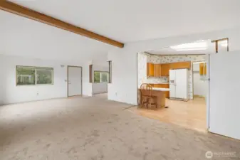 Open living area with vaulted ceilings and natural flow into the kitchen and dining spaces.