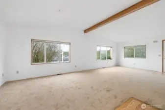 Large living room with expansive windows that bring in natural light and neighborhood views.