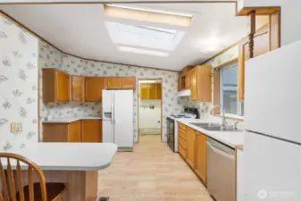 Bright kitchen featuring skylight, ample cabinetry, and convenient breakfast bar seating.