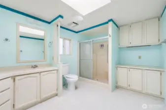 Primary bath with double vanity, generous cabinet space, and convenient easy-access shower.