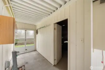 Versatile shop/storage space with workbench, shelving, and easy access to the backyard.