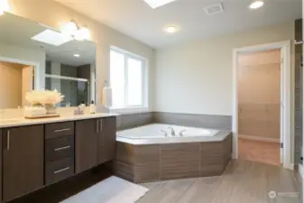 Primary 5 piece En Suite with floating, dual vanity with quartz countertop, garden tub, oversized shower and  large walk-in closet.