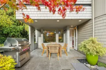 The lower-level patio provides an additional alfresco dining experience. Surrounded by lush greenery, the west-facing patio captures the evening light.