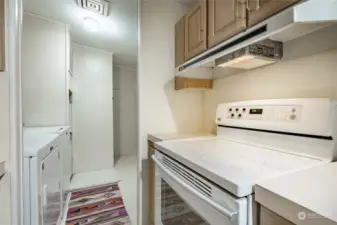 Laundry room next to kitchen and unfinished storage room.