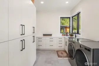 Huge laundry room loaded with storage, sink and plenty of countertop for folding or projects. Quartz counter top.