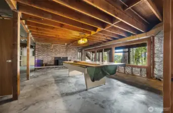 Unfinished space in basement used for the pool table.