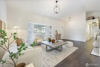 Vaulted ceiling and bay windows elevate the spacious feel of this light and bright living room.