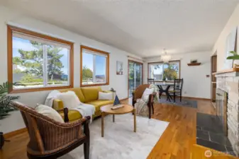 The main living area has large windows that look over the pack yard and partial water and mountain views. The cozy fireplace and original hardwood floors are an extra bonus in this home!