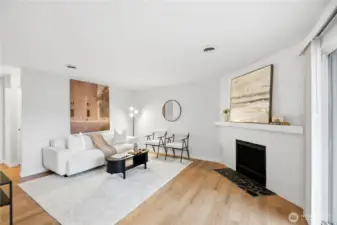 Spacious, open living room with abundant natural light and a cozy wood-burning fireplace.