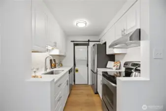 The galley kitchen entry has been creatively opened to improve flow and provide a brighter, more open and spacious feel.