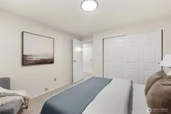 This secondary bedroom utilizes its expansive window to maximize the 'open-concept' feel of the home, supported by a walk-in closet designed for the modern lifestyle.