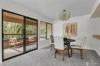 Dining area is subtly separated from the kitchen, with sliding glass doors that open up to a private balcony, offering serene park views.