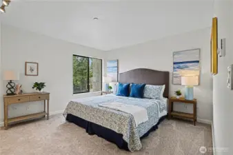 The spacious primary bedroom bathed in natural light, offering a peaceful and refreshing atmosphere to unwind.