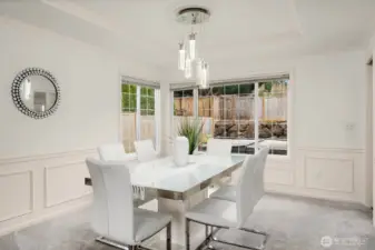 The elegant formal dining room features classic wainscoting, a statement pendant light, and a bright bay window — ideal for hosting dinner parties and special gatherings.