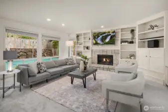 The spacious family room impresses with a cozy fireplace, custom built-in shelving, and expansive picture windows overlooking the private backyard — a perfect gathering space for everyday living.