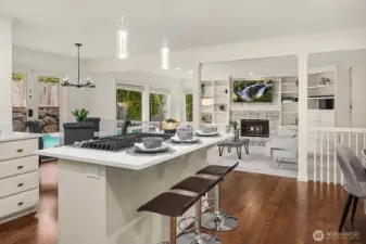 This stunning kitchen showcases crisp white cabinetry, pendant lighting over the island, and a seamless open sightline to the family room and backyard, the true heart of this exceptional home.