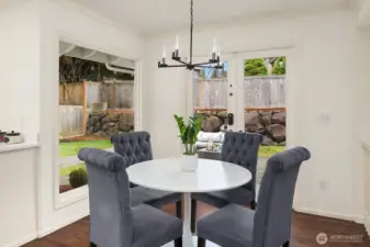 A charming breakfast nook with a elegant pendant light and sun-filled windows creates the perfect casual dining spot, flowing naturally from the kitchen for easy everyday living.